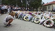FILE: A woman kneels down by a floral tribute by the Bondi Pavilion at Bondi Beach, 16 December 2025