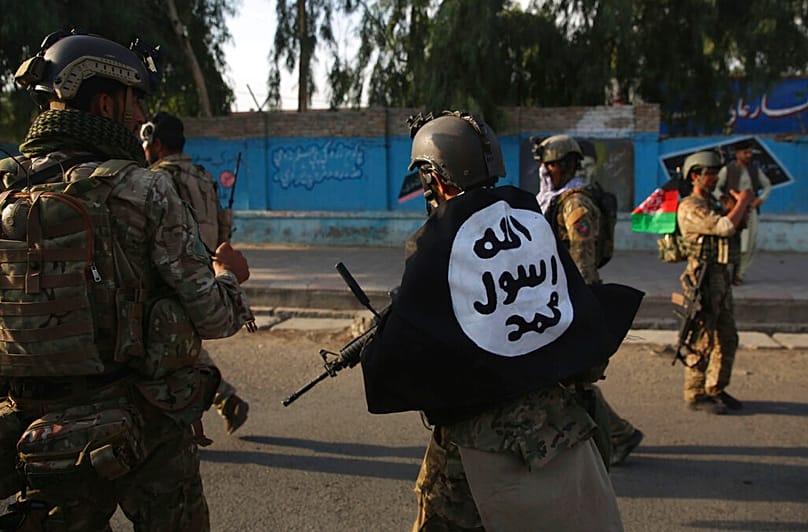 عنصر من الأمن الأفغاني يغطي جسده بعلم تنظيم داعش عقب هجوم في مدينة جلال آباد شرق كابول، في 3 أغسطس 2020.