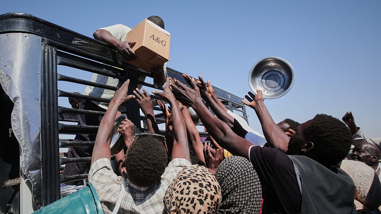 Sudan El Faşir'de aileler bir kamyondan yardım malzemelerine ulaşmaya çalışırken, 16 Kasım 2025