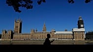 FILE: A pedestrian passes Britain's Houses of Parliament on the bank of The River Thames in London, Aug. 29, 2019.