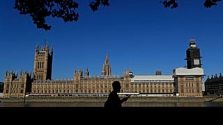 FILE: A pedestrian passes Britain's Houses of Parliament on the bank of The River Thames in London, Aug. 29, 2019.