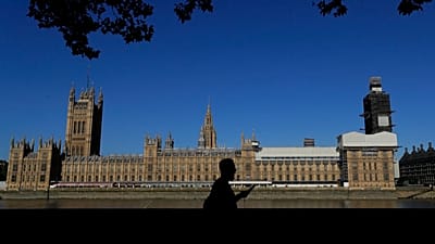 FILE: A pedestrian passes Britain's Houses of Parliament on the bank of The River Thames in London, Aug. 29, 2019.