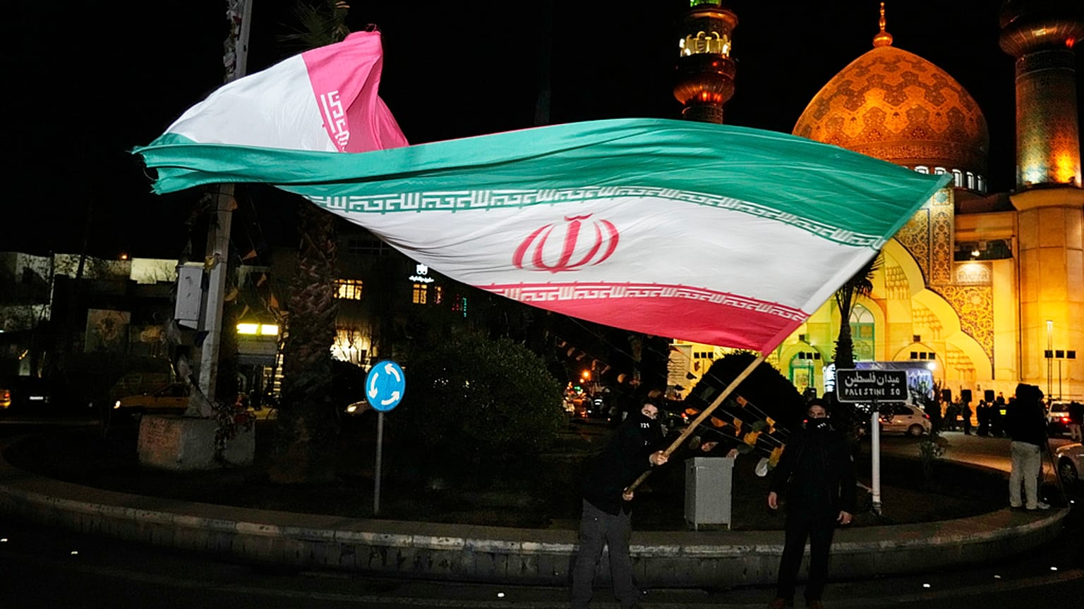 متظاهر يلوح بالعلم الإيراني احتفالاً بالإعلان عن اتفاق وقف إطلاق النار بين حماس وإسرائيل، في ساحة فلسطين بطهران، إيران، الخميس 16 يناير/كانون الثاني 2025. 