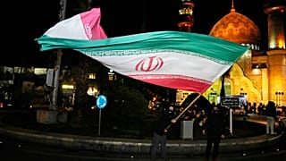 متظاهر يلوح بالعلم الإيراني احتفالاً بالإعلان عن اتفاق وقف إطلاق النار بين حماس وإسرائيل، في ساحة فلسطين بطهران، إيران، الخميس 16 يناير/كانون الثاني 2025. 