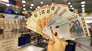 Πωλητής εκθέτει χαρτονομίσματα ευρώ σε κατάστημα στο Βίλνιους, Λιθουανία. 1 Ιαν. 2015.