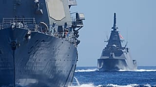 ناوچه نیروی دریایی دفاعی ژاپن در سمت راست و ناوشکن نیروی دریایی آمریکا در حال مانور در آب‌های مورد مناقشه دریای جنوبی چین، جمعه ۲۸ مارس ۲۰۲۵