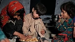 Afgan çocuklar Paktika vilayetinin Gayan ilçesinde meydana gelen depremin ardından derme çatma bir barınakta yemek yiyor, 25 Haziran, 2022