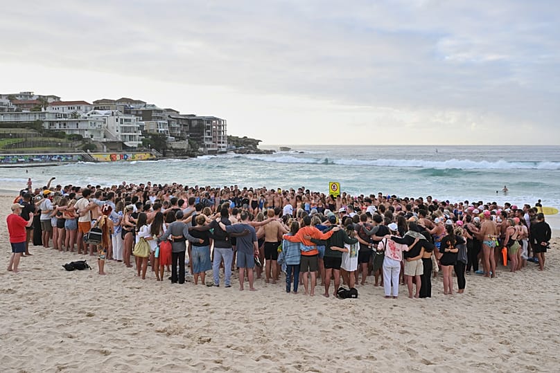 Nadadores se reúnen para una vigilia matutina en Sídney, el miércoles 17 de diciembre de 2025, tras el tiroteo del domingo en Bondi Beach. 
