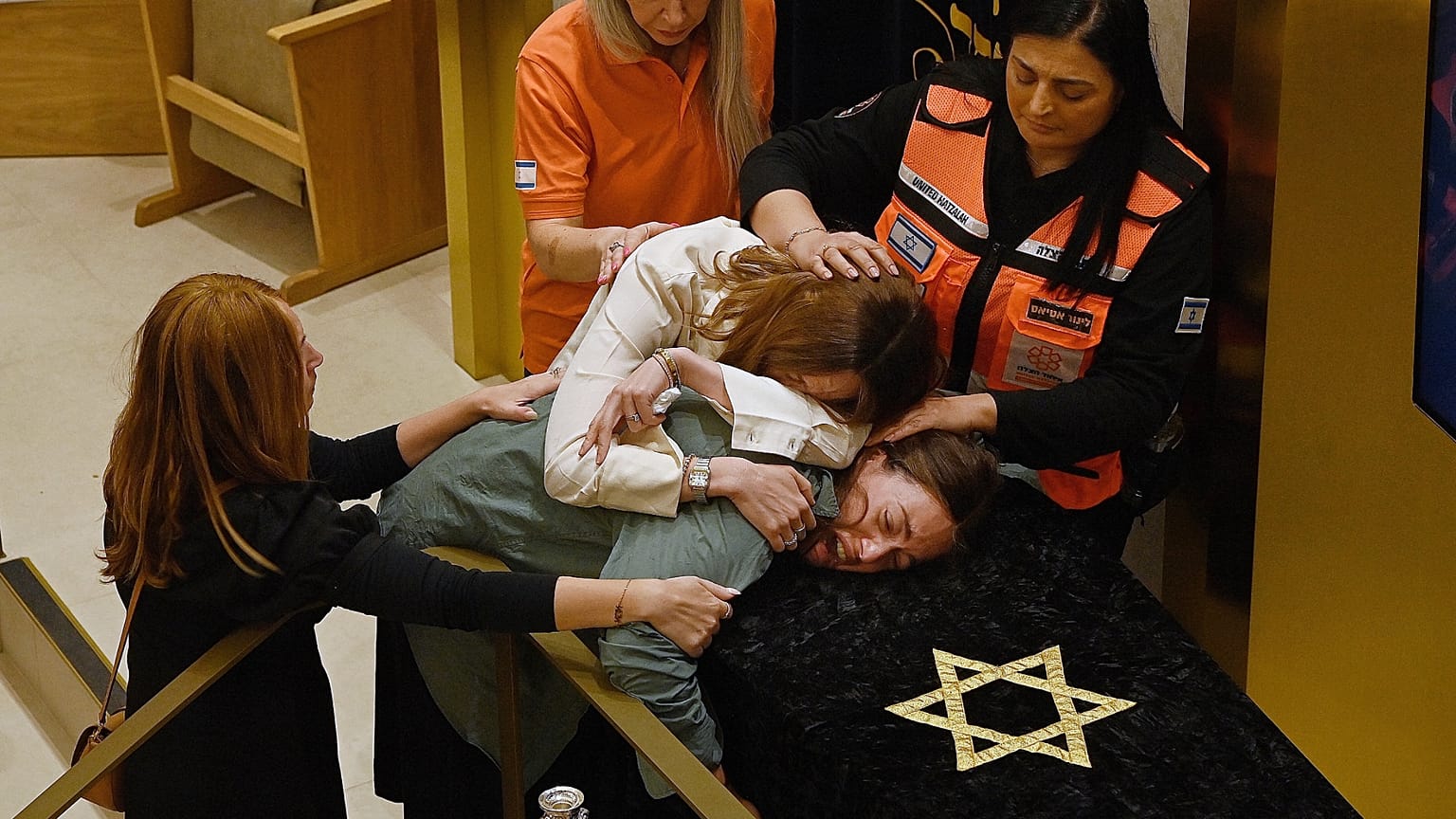 Relatives of Rabbi Eli Schlanger, who was killed in the Bondi shootings, react over his coffin during his funeral at Synagogue in Bondi, Sydney, Wednesday, Dec. 17, 2025.