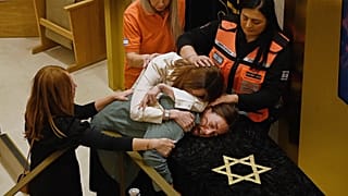 Relatives of Rabbi Eli Schlanger, who was killed in the Bondi shootings, react over his coffin during his funeral at Synagogue in Bondi, Sydney, Wednesday, Dec. 17, 2025.