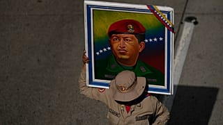 عضو في الميليشيا البوليفارية يحمل ملصقًا للرئيس الراحل هوغو تشافيز خلال تجمع احتفالي بمناسبة عيد ميلاده في كاراكاس، فنزويلا، يوم الاثنين 28 يوليو 2025. 