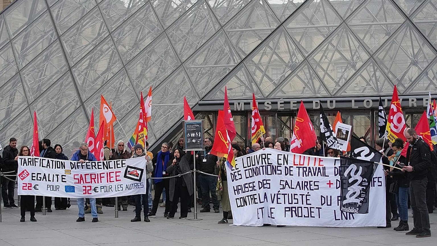 Unionists display a banner and union flags outside the Louvre museum in Paris, 17 December, 2025 