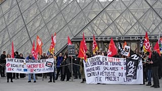 Unionists display a banner and union flags outside the Louvre museum in Paris, 17 December, 2025 
