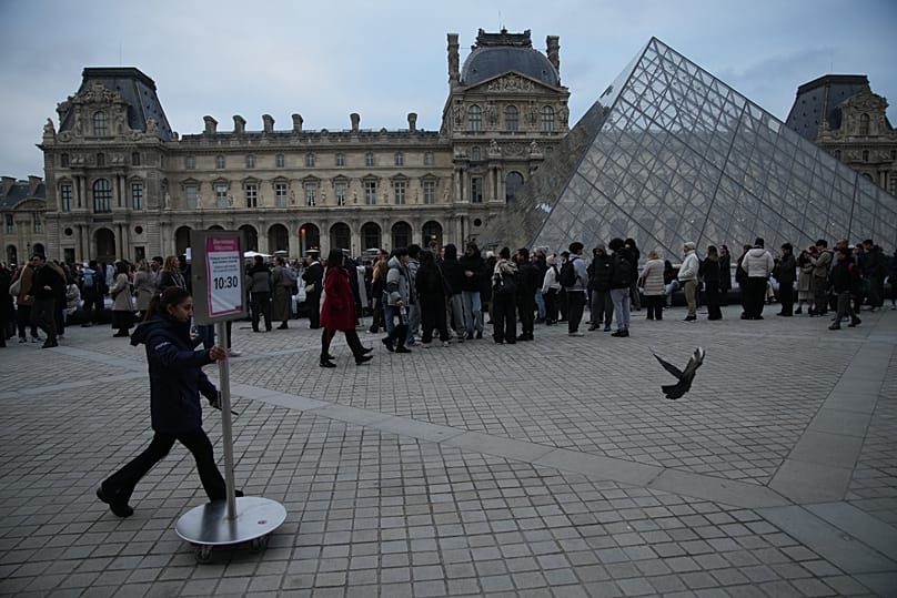 People wait at the entrance of the Louvre museum as employees were set to vote on whether to extend a strike, 17 December, 2025