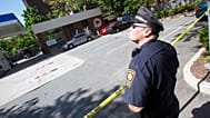 FILE: A Brookline police officer stands at the scene of an FBI investigation at a service station in Brookline, MA., 13 May 2010