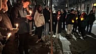 A crowd of people holding candles gather outside the home of Massachusetts Institute of Technology professor Nuno F.G. Loureiro in Brookline