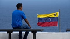 Venezuela La Guaira'da denize karşı bankta oturan bir kişi, 17 Aralık 2025