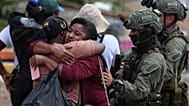 A police officer, comforts residents after an attack that the government blamed on dissidents of the FARC, in Buenos Aires, Colombia, Dec. 17, 2025 