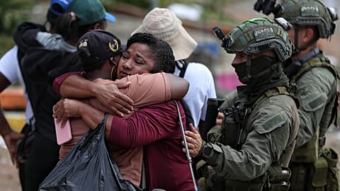 Un agente di polizia consola gli abitanti dopo un attacco attribuito dal governo ai dissidenti delle Farc, a Buenos Aires, Colombia, il 17 dicembre 2025