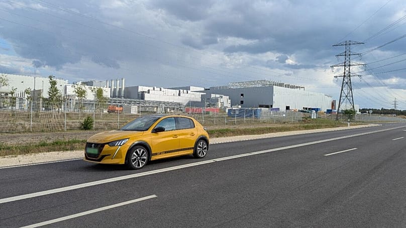 Elektromos autó halad a Samsung gödi óriásgyára előtt