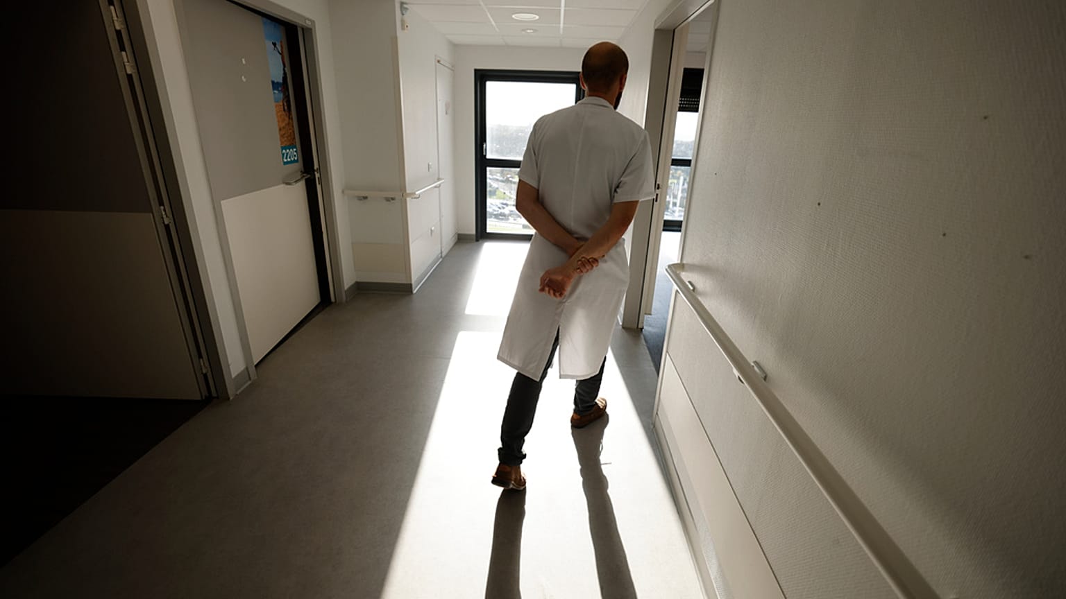 صورة تعبيرية لطبيب يسير في ممر وحدة الرعاية التلطيفية بالمستشفى العام في بولون سور مير، شمال فرنسا