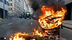 Un feu brûle dans un tonneau alors que les agriculteurs européens bloquent une route avec leurs tracteurs lors d'une manifestation à l'extérieur du sommet de l'UE à Bruxelles, le 18 décembre 2025.