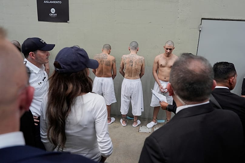 Shackled prisoners stand against a wall as Homeland Security Secretary Kristi Noem tours the Terrorism Confinement Center in Tecoluca, Salvador, March 26, 2025. (AP Photo)