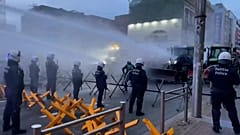 کشاورزان تراکتورهای خود را به سوی پلیس می‌رانند در حالی که از ماشین‌های آب‌پاش علیه آن‌ها استفاده می‌شود