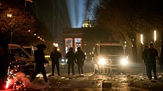 Polizeibeamte stehen nach dem Feuerwerk zu Neujahr in Berlin, Deutschland, am Mittwoch, dem 1. Januar 2025, auf Streife