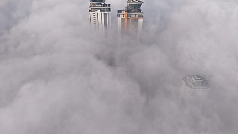 Veduta aerea di edifici che emergono da una fitta coltre di nebbia a Sarajevo.