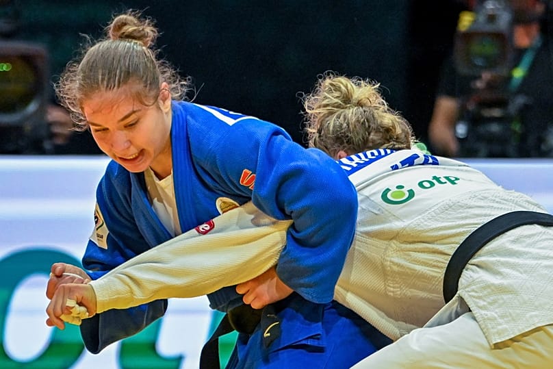 Özbas Szofi (kékben) és az olasz Giorgia Stangherlin küzd a cselgáncs-világbajnokság vegyes csapatversenyében a Papp László Budapest Sportarénában 2025. június 20-án 