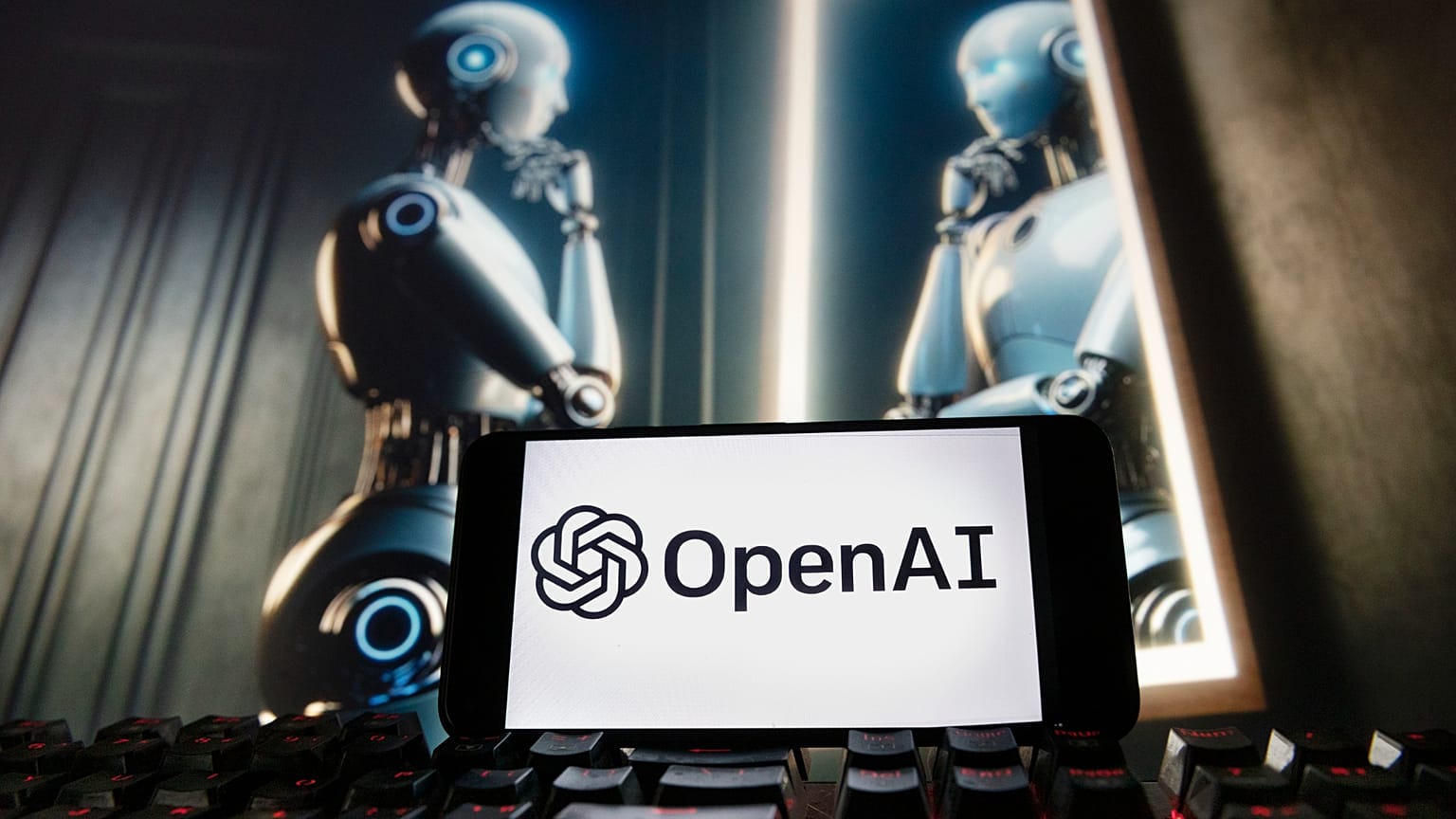 Архивное фото: логотип OpenAI на экране телефона, на мониторе изображение, созданное моделью генерации изображений по тексту DALL·E в ChatGPT. 8 декабря 2023 года, Бостон.