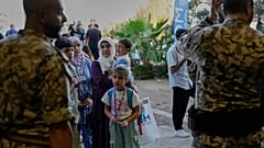 Члены семьи сирийских беженцев ждут проверки ливанскими службами безопасности перед посадкой в автобус, чтобы вернуться домой в Сирию, 11 сентября 2025 г.