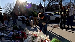 Uma mulher acende uma vela num memorial montado em frente ao edifício de engenharia Barus and Holley na Universidade Brown, em Providence, Rhode Island, na quinta-feira