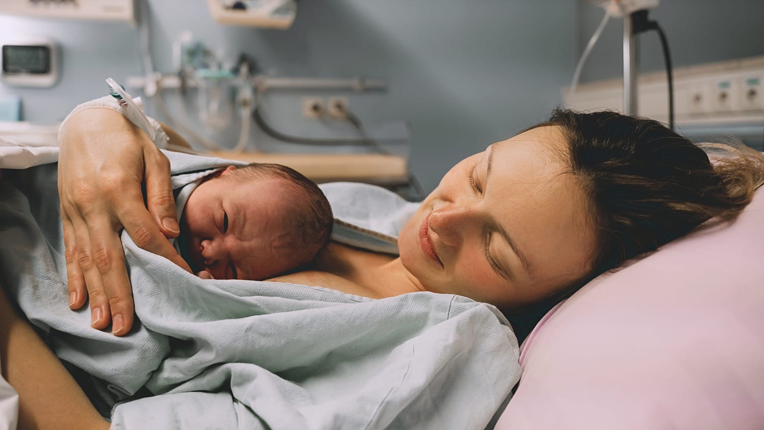 Une mère serrant son nouveau-né dans ses bras à l'hôpital peu après l'accouchement. (Source : Natalia Deriabina, Shutterstock)