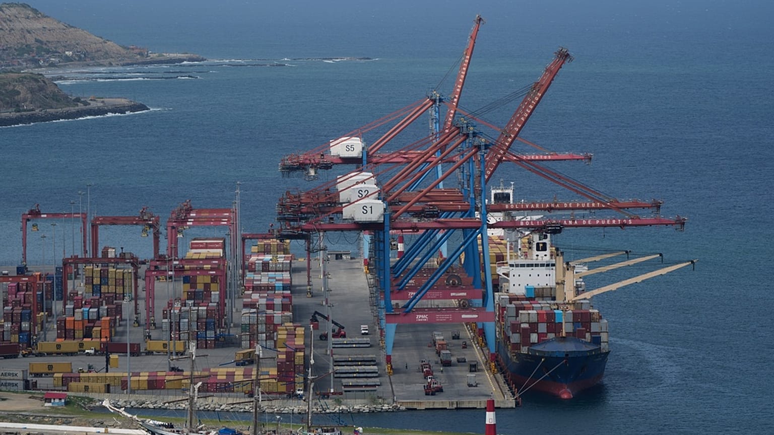 FILE - A cargo boat is docked below cranes at the seaport in La Guaira, Venezuela. 17 December 2025.