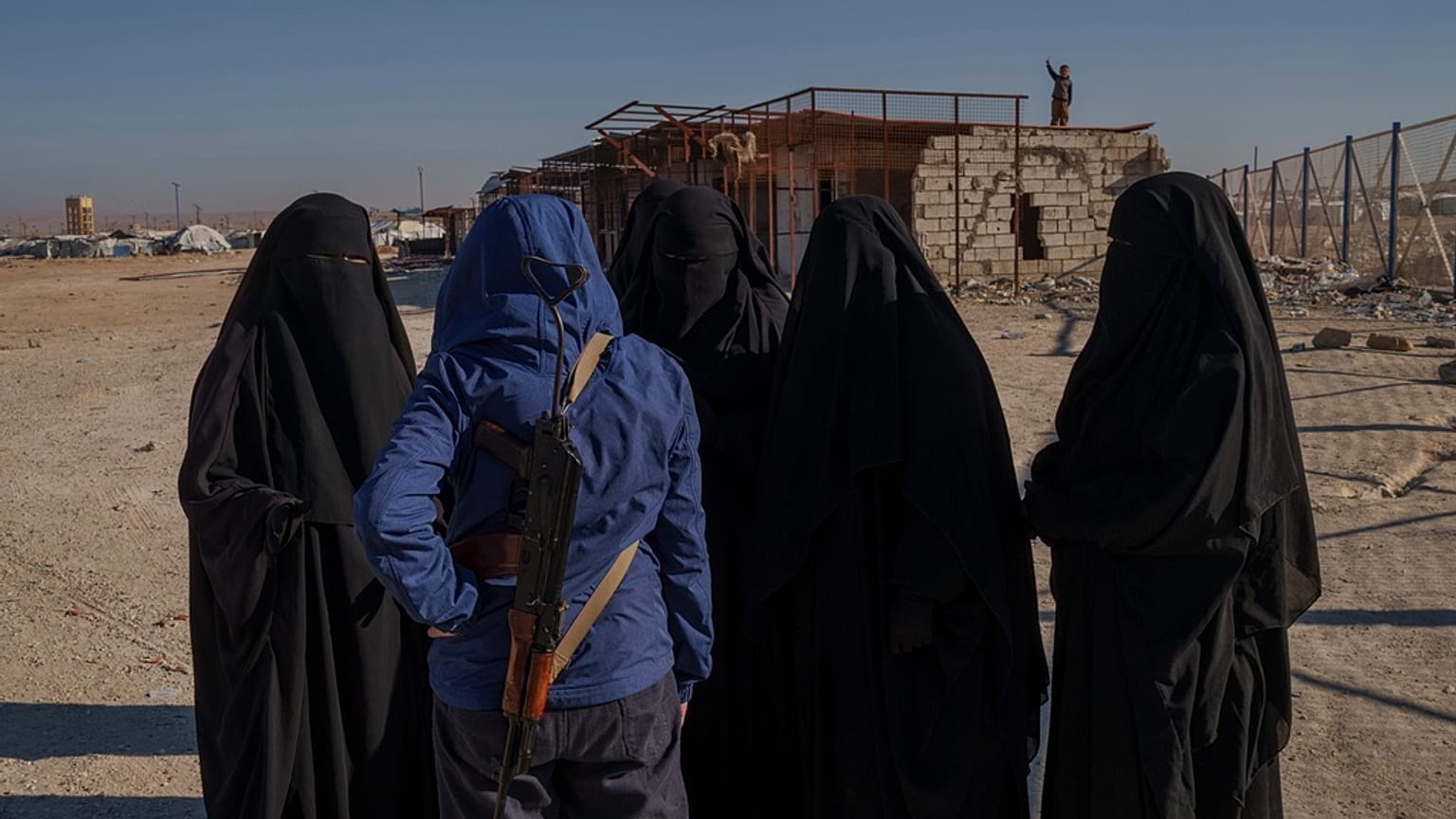 صورة تعبيرية- أحد أفراد قوات سوريا الديمقراطية يتحدث إلى نساء مسلمات صينيات داخل مخيم الهول للاحتجاز في محافظة الحسكة شمال شرق سوريا