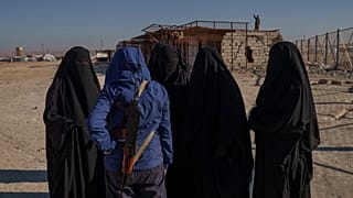 صورة تعبيرية- أحد أفراد قوات سوريا الديمقراطية يتحدث إلى نساء مسلمات صينيات داخل مخيم الهول للاحتجاز في محافظة الحسكة شمال شرق سوريا