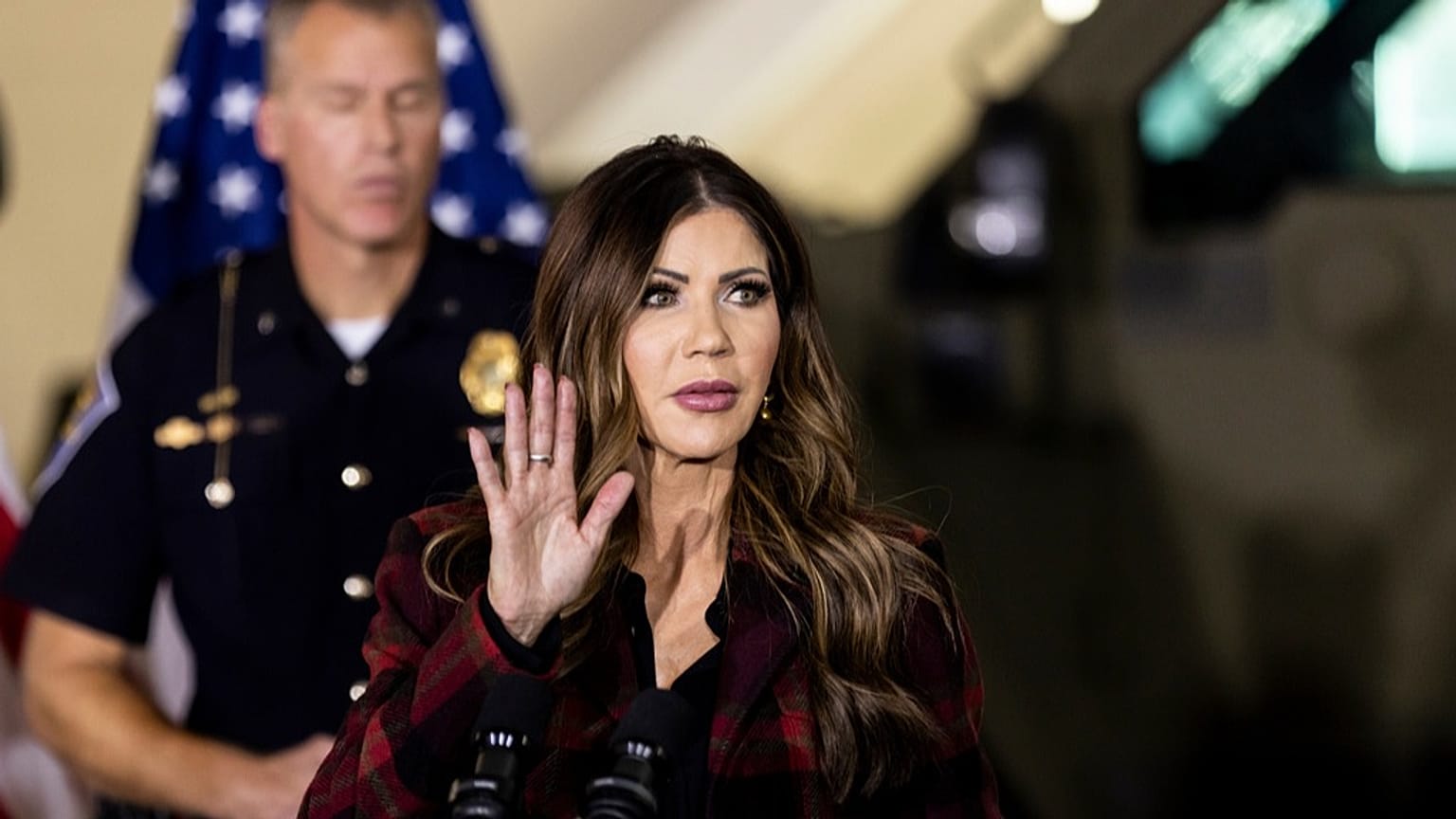 يراقب قائد شرطة ولاية إنديانا، أنتوني سكوت، وزيرة الأمن الداخلي الأمريكية، كريستي نويم، أثناء مناقشتها للنتائج الأخيرة لعملية "ميدواي بليتز" خلال مؤتمر صحفي في منشأة للحرس الو