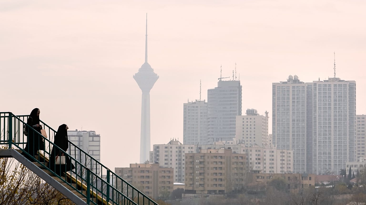 امرأتان تعبران جسراً علوياً في طهران، إيران، الأحد 7 ديسمبر 2025. (صورة من وكالة أسوشيتد برس/وحيد سالمي)