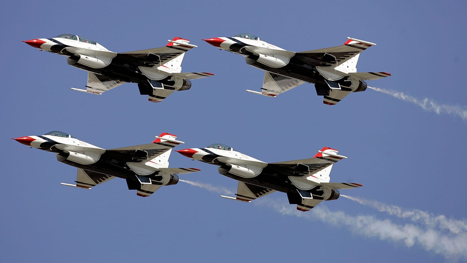 أربع طائرات من فريق "Thunderbirds" للقوات الجوية الأمريكية تحلق في تشكيل خلال عرض جوّي