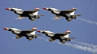 أربع طائرات من فريق "Thunderbirds" للقوات الجوية الأمريكية تحلق في تشكيل خلال عرض جوّي