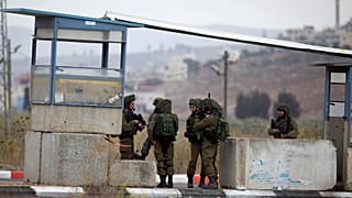 جنود إسرائيليون يؤمنون المنطقة بعد أن أطلق مسلح فلسطيني النار على موقع عسكري وردّت القوات النيران عند حاجز هوارا جنوب مدينة نابلس في الضفة الغربية