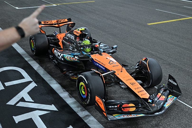 A pillanat, amikor Lando Norris McLarenje áthalad a célvonalon Abu-dzabiban, amivel a brit pilóta a Forma-1 új világbajnoka lett  2025. december 7-én
