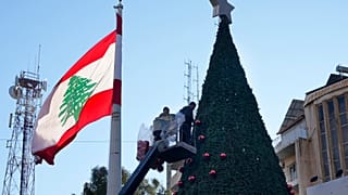 عمال يقفون على رافعة لتزيين شجرة عيد ميلاد عملاقة في حي الأشرفية، في بيروت، لبنان، الأحد 1 ديسمبر 2024.