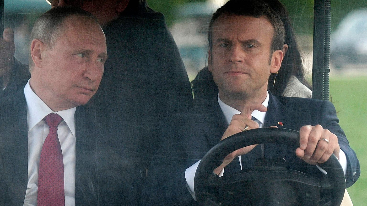 Emmanuel Macron conduit une voiturette de golf électrique avec Vladimir Poutine dans le jardin du château de Versailles, le 29 mai 2017. 