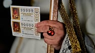Un espectador sostiene un boleto de lotería antes del inicio del sorteo de Navidad, conocido como El Gordo, en el Teatro Real de Madrid, el lunes 22 de diciembrede 2025.