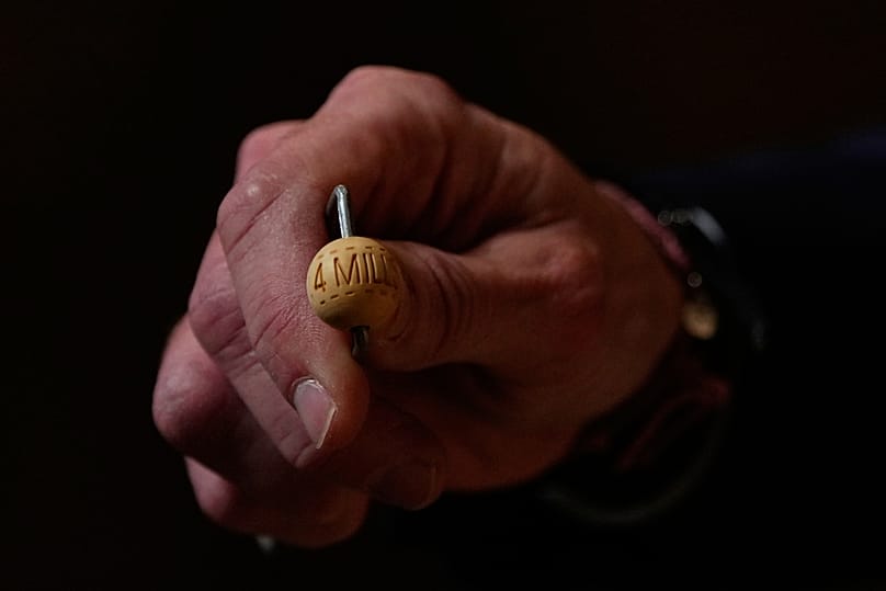 Un miembro del personal de la lotería muestra una bola de lotería de El Gordo antes del sorteo anual de Navidad, en Madrid, el 22 de diciembre de 2025.