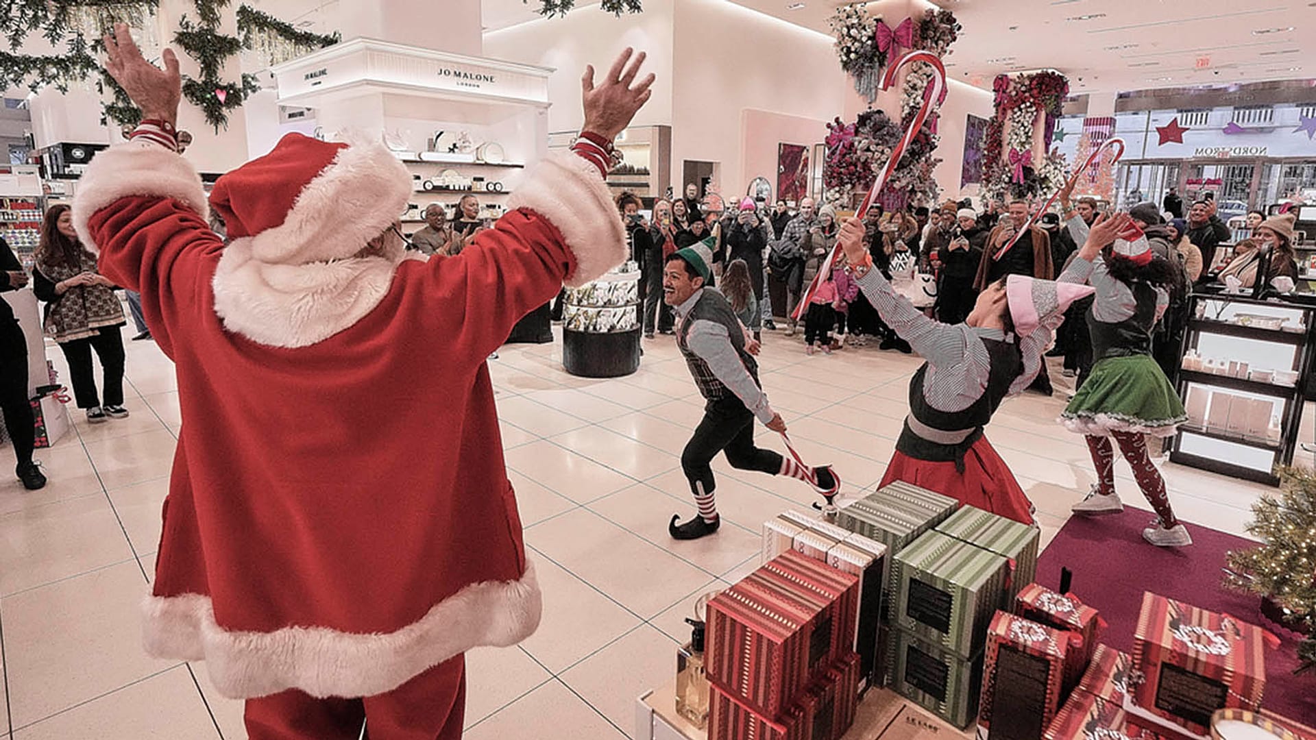 Pessoas representando o Pai Natal e os seus duendes actuam na secção de cosméticos de uma loja de departamentos Nordstrom, em Nova Iorque, a 8 de dezembro de 2025