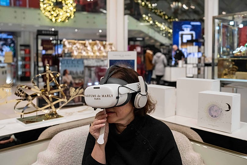 Associated Press reporter Anne D'Innocenzio smells perfume while using a VR headset by Parfum de Marly Paris at Macy's flagship store, 21 November 2025, in New York.
